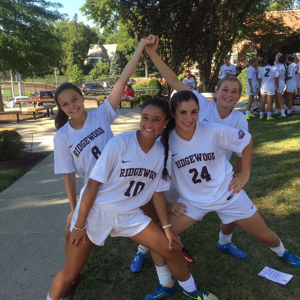 Seniors Josie Clark, Adrianna Fernandez, Rebecca Feder, and Alison Simpson posing for a picture in their uniforms.